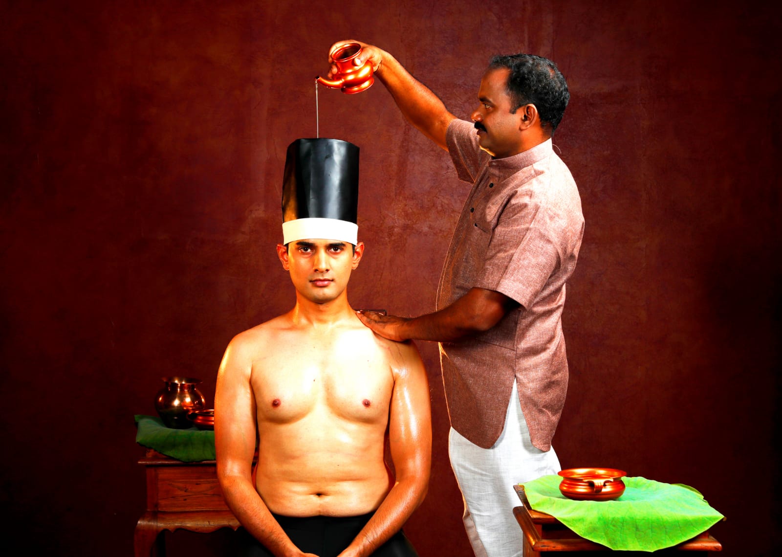 shirodhara-practitioner pouring oil to a man's head