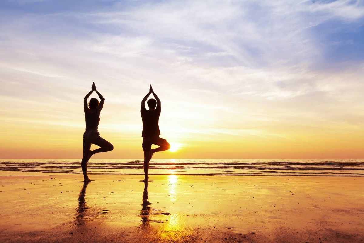 yoga posture-vrukshasana standing on one leg beach sunset