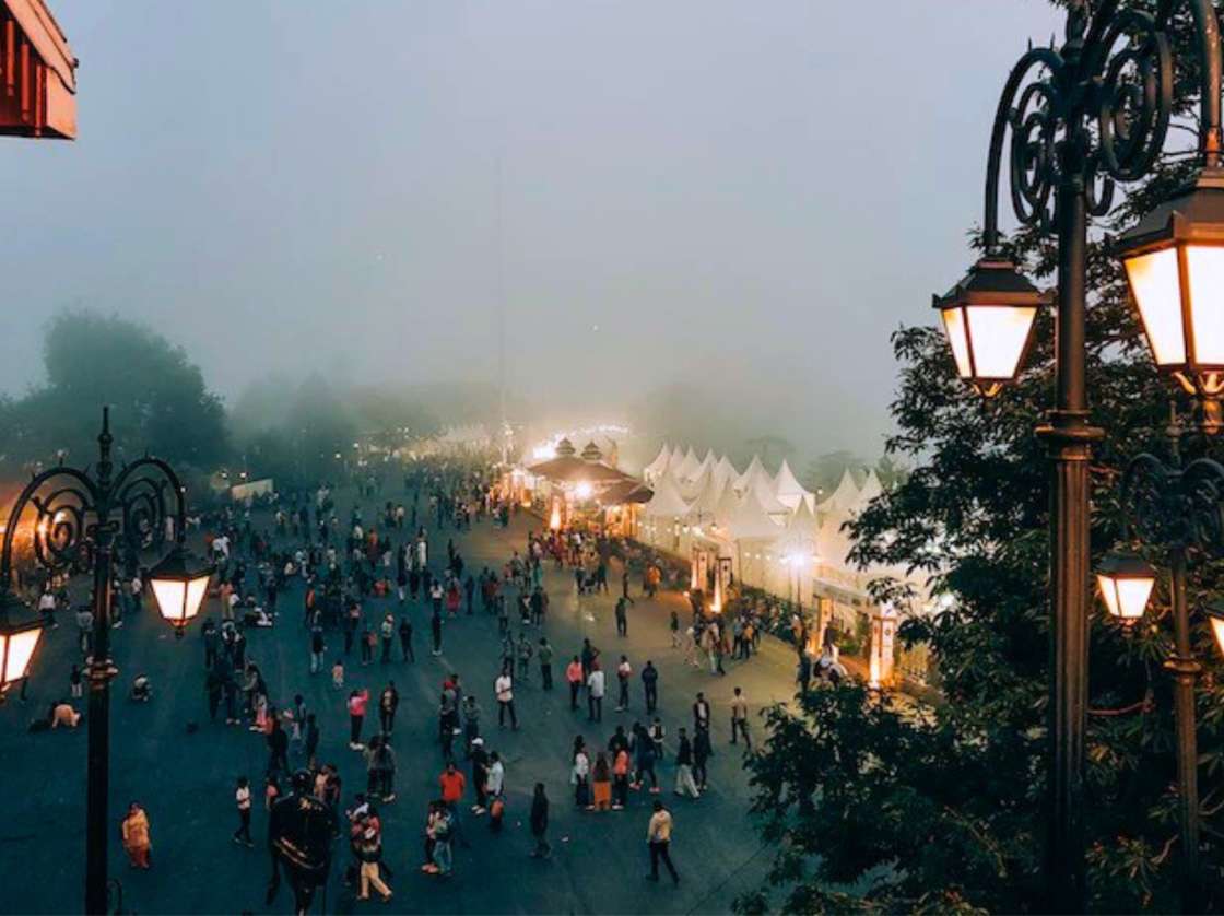 people walking through shopping street in foggy twilight